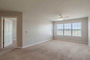 A room with a ceiling fan and a door.